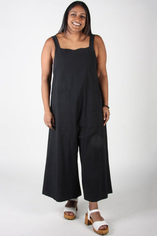 Woman wearing relaxed fit black cotton Dusky Greygone jumpsuit by Birds of North America. 