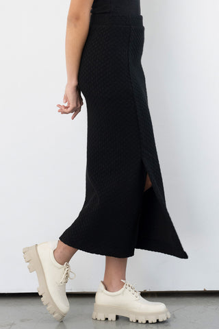 Side view of model wearing slim fit black midi Smith Skirt by Bodybag.
