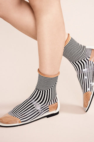 Close-up of women's legs wearing black and white stripe Corbusier rolled top crew socks. 