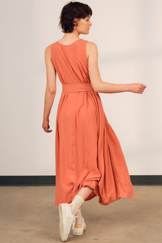 Model wearing coral belted Alethea maxi dress by Jennifer Glasgow. 