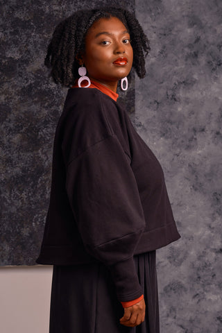 Side view of model wearing black OEKO-TEK tencel organic cotton blend Clyde Sweater by Jennifer Glasgow. 
