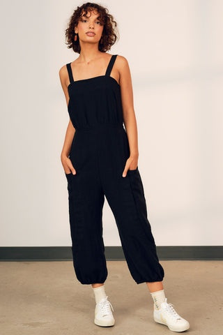 Model wearing black OEKO-TEK linen Danu jumpsuit by Jennifer Glasgow. 
