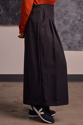 Side view of model wearing navy black OEKO-TEK Tencel wide leg pleated Harlow pants by Jennifer Glasgow. 