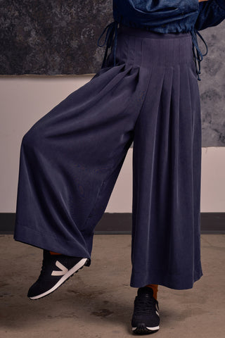 Model wearing navy blue OEKO-TEK Tencel wide leg pleated Harlow pants by Jennifer Glasgow. 