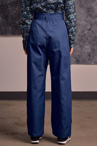 Back view of model wearing blue organic cotton Lozen pants by Jennifer Glasgow.