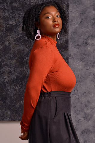 Side view of model wearing red long sleeve mock neck Myla top by Jennifer Glasgow. 