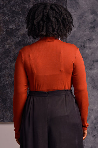 Back view of model wearing red long sleeve mock neck Myla top by Jennifer Glasgow. 