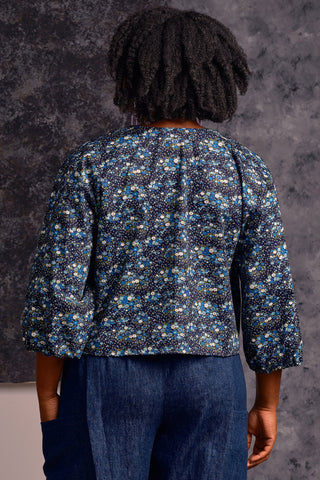 Back view of model wearing blue floral print Sakima Top by Jennifer Glasgow. 