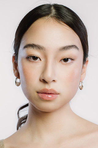 Model wearing sterling silver and pearl Luna Hoop Earrings by Kara Yoo. 