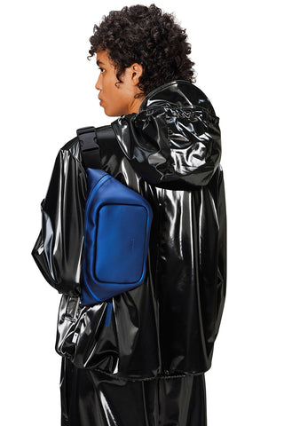 Model wearing deep blue waterproof Bum Bag Mini W3 by Rains.