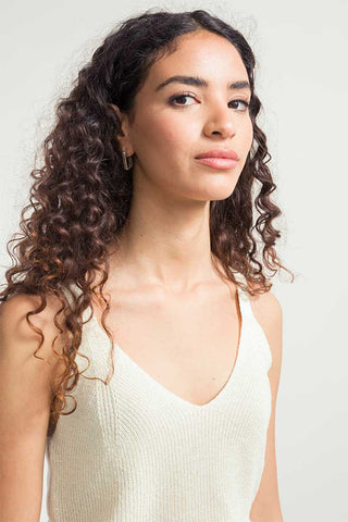 Woman wearing white v-neck recycled silk Grace tank top by Rifo. 