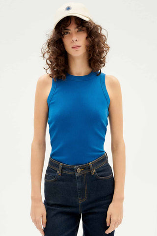 Woman wearing blue organic cotton Juliette tank top by Thinking Mu. 