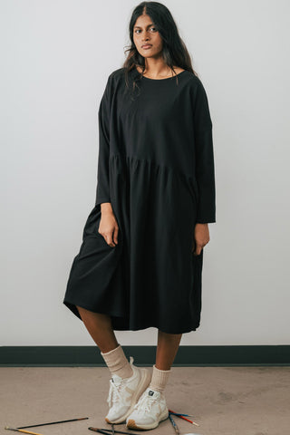 Model wearing Jennifer Glasgow Mazu dress in black organic cotton. 
