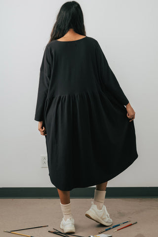 Back view of model wearing Jennifer Glasgow Mazu dress in black organic cotton. 
