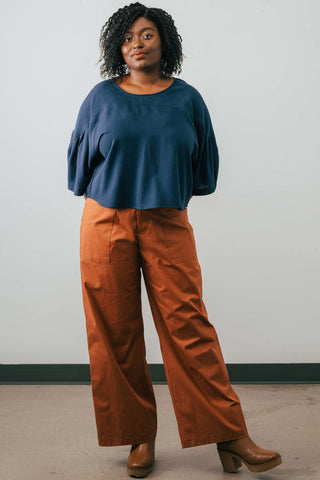 Model wearing organic cotton Jennifer Glasgow Moray pants in rust. 