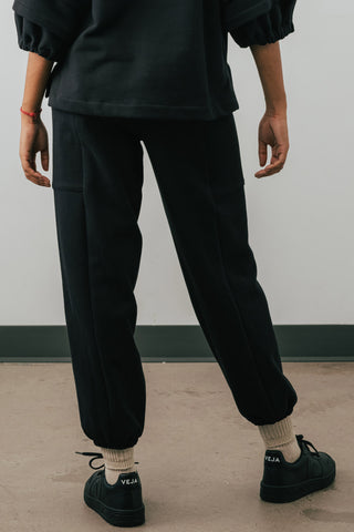 Back view of model wearing black colour organic cotton Jennifer Glasgow Ridley Sweatpants. 