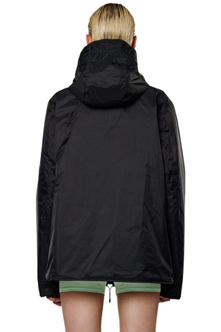 Back view of model wearing black insulated waterproof RAINS Fuse jacket. 