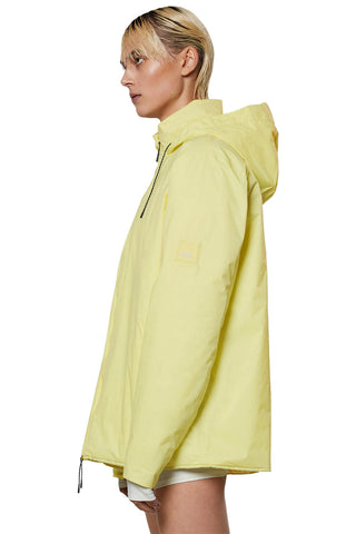 Side view of model wearing yellow (straw) insulated waterproof RAINS Fuse jacket. 
