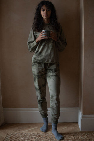 Woman wearing olive tie dye organic cotton track pants by The Simple Folk. 