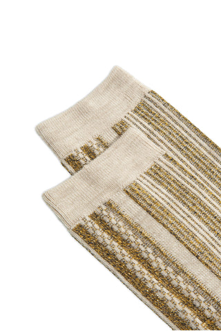 Close-up of a pair of cream and gold stripe pattern socks. 