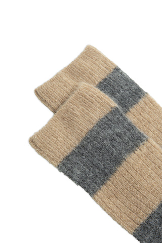Close-up of tops of taupe and grey ribbed knit striped socks against white background. 