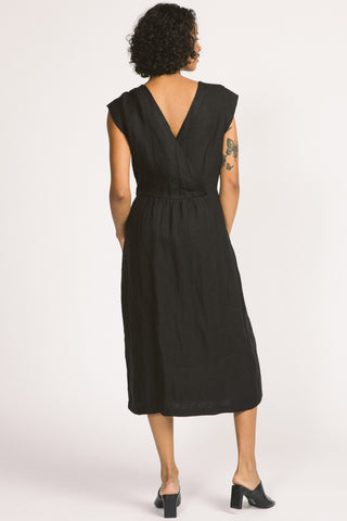 Back view of woman wearing black linen midi Blythe dress by Allison Wonderland. 