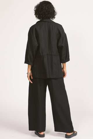 Back view of woman wearing loose fitting black linen Greer blazer by Allison Wonderland. 