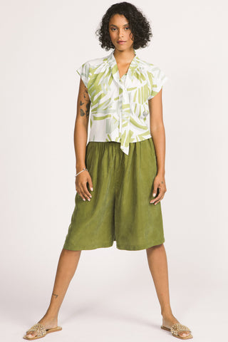 Woman wearing green and white leaf print Isabeau pussy bow blouse by Allison Wonderland. 