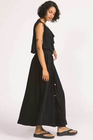 Side view of woman wearing black maxi length Oriana Skirt by Allison Wonderland. 