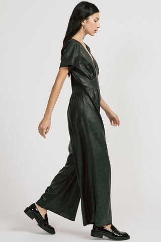 Model wearing black shiny wide leg Spirited Jumpsuit by Allison Wonderland. 