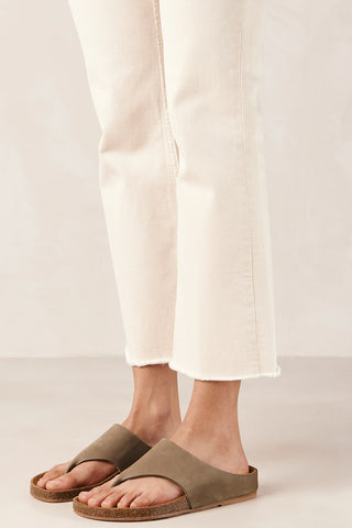 Woman wearing cream jeans and tan coloured leather Ivy Sandals by Alohas. 