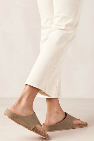 Woman wearing cream jeans and tan coloured leather Ivy Sandals by Alohas. 