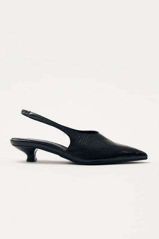 Side view of black leather kitten heel sling back pumps on white background. 