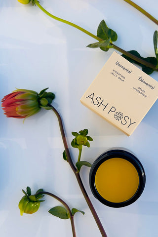Container of Ash Posy Elemental Hydrating Jelly Balm with flowers. 