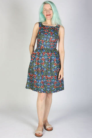Woman wearing knee length sleeveless multi-colour floral dress. 
