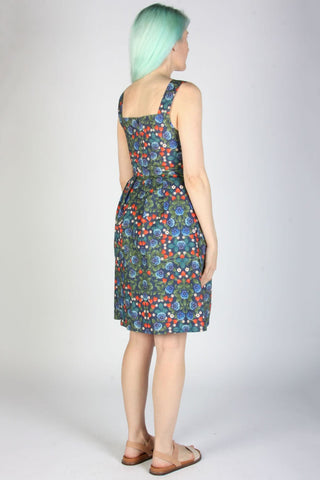 Back view of woman wearing knee length sleeveless multi-colour floral dress. 