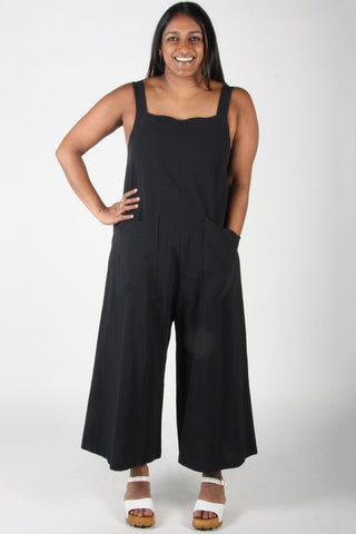 Woman wearing relaxed fit black cotton Dusky Greygone jumpsuit by Birds of North America. 
