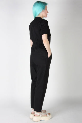Back view of woman wears black zip up Nonpareil boilersuit by Birds of North America. 