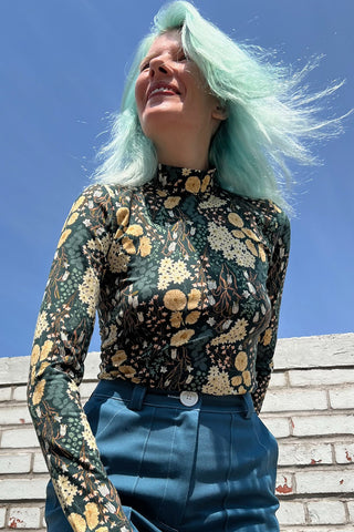 Designer Hayley wearing Bellflower print long sleeve mock neck Nuncie top by Birds of North America. 