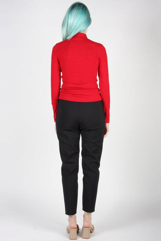 Back view of woman wearing black cropped tapered leg Tern pants by Birds of North America. 