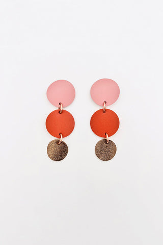 Earrings with pink, orange and gold leather circles joined with brass rings. 