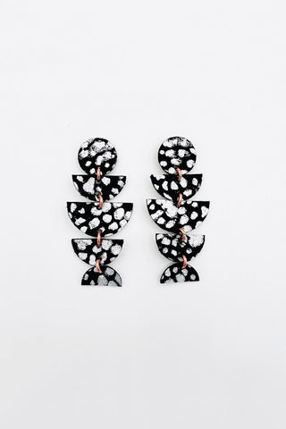 Black and white dangle earrings made from various leather shapes. 