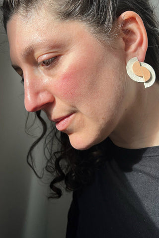 Model wearing recycled leather Blisscraft Meridian Dawn  earrings. 