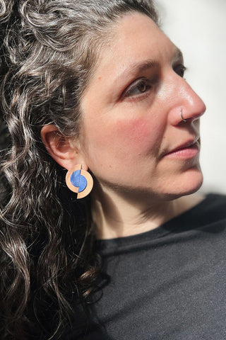 Model wearing recycled leather Blisscraft Meredian Moon earrings. 