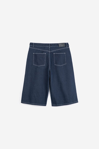 Back view of dark blue denim bermuda shorts with white contrast stitching. 