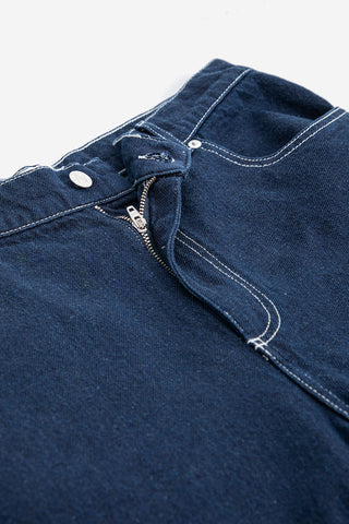 Waistband of dar blue denim bermuda shorts with white contrast stitching. 