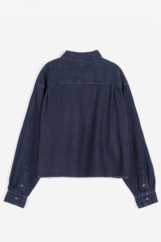 A dark navy blue denim shirt shown from the back, with long sleeves with buttoned cuffs, and a relaxed fit, photographed against a clean white background.