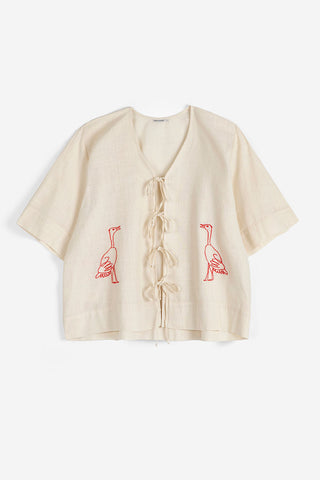 Cream blouse with tie up front and red embroidered birds. 