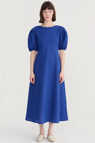 Woman wearing blue midi length dress with balloon sleeves. 