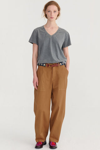 Woman wearing grey t-shirt and brown loose fitting pants. 